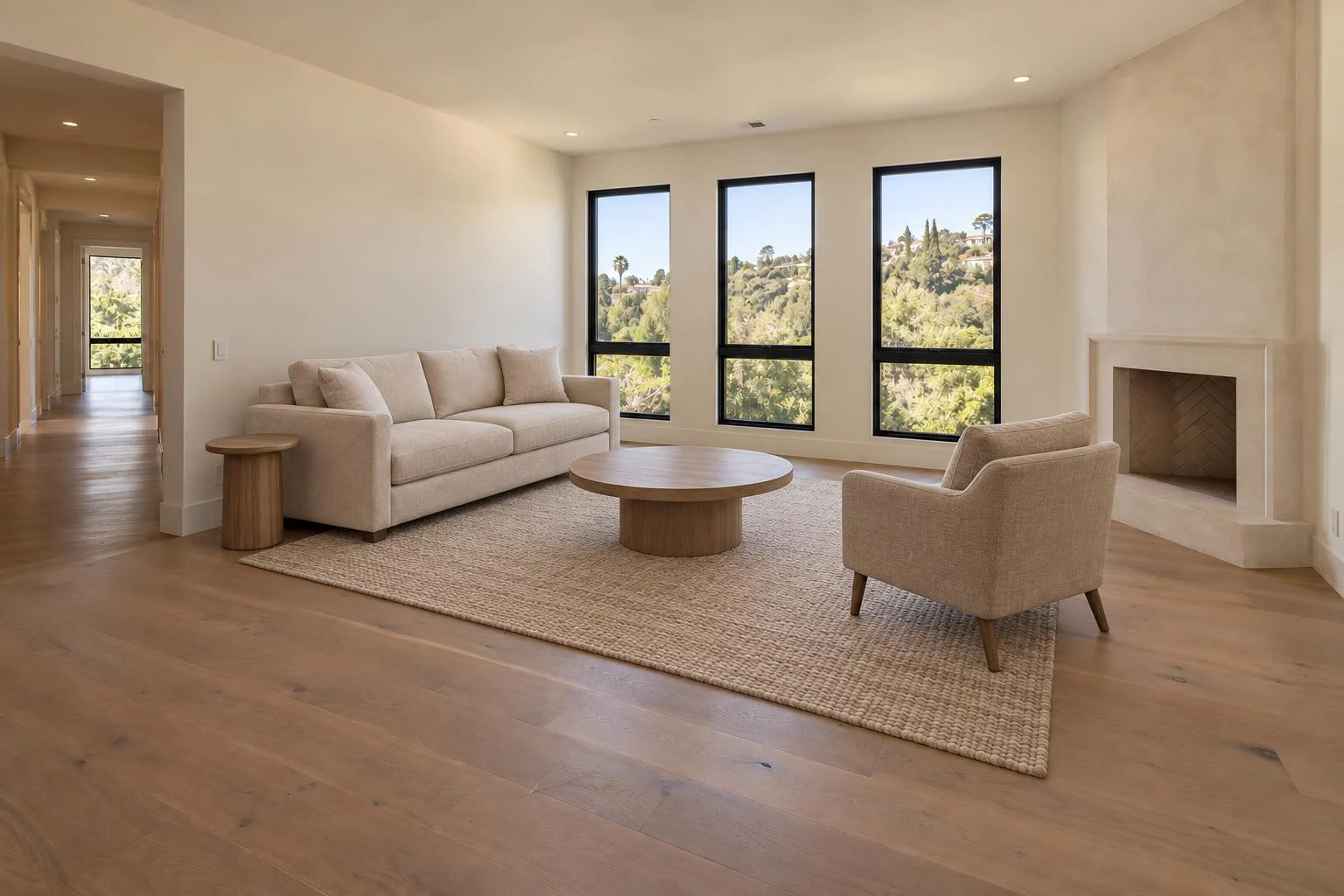 The same fictional living room staged with a cream sofa, armchair, oak coffee table and rug
